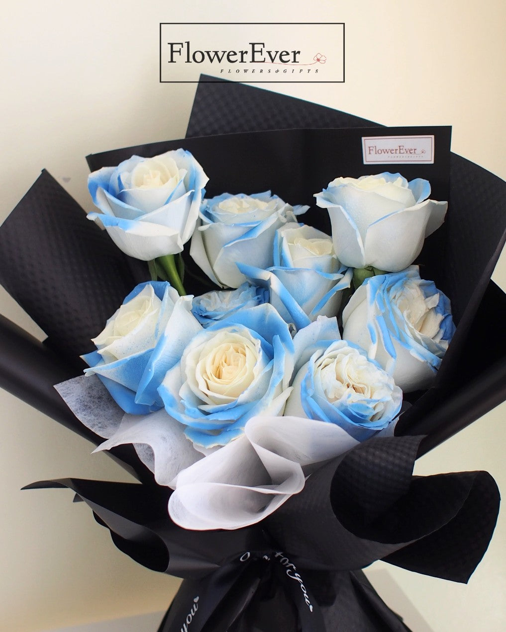 12 Stems of Elegance: Ice Blue Roses in Black Paper Bouquet