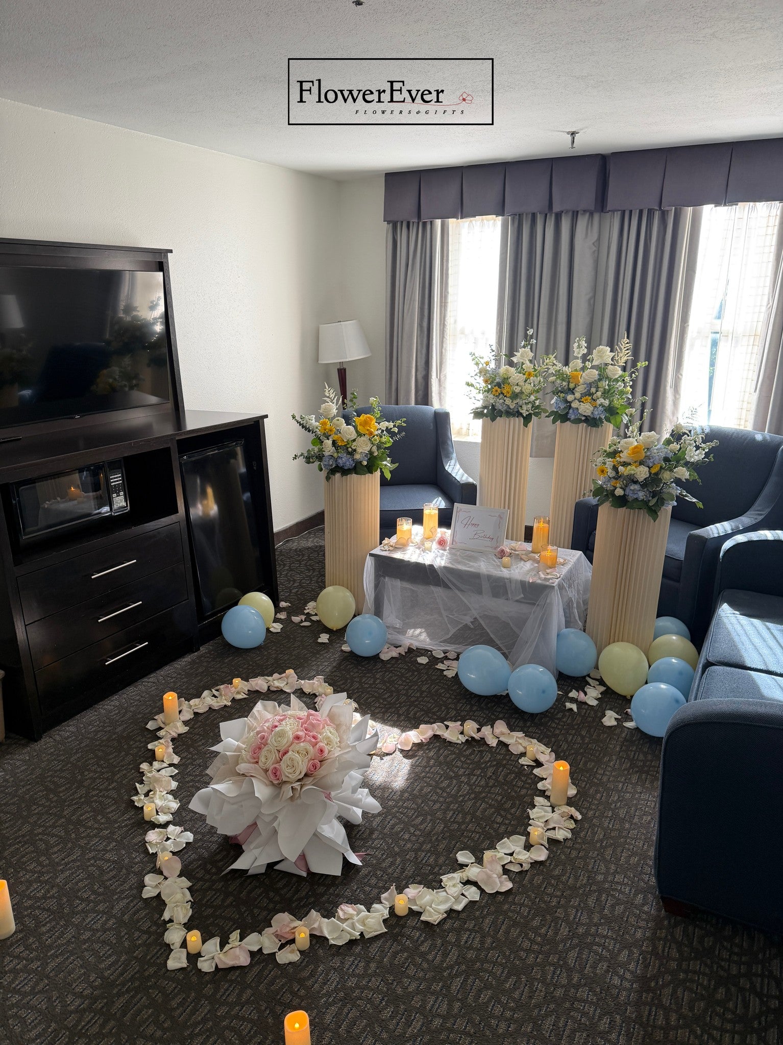 Decorated living room with floral arrangements and balloons, featuring FlowerEver branding.