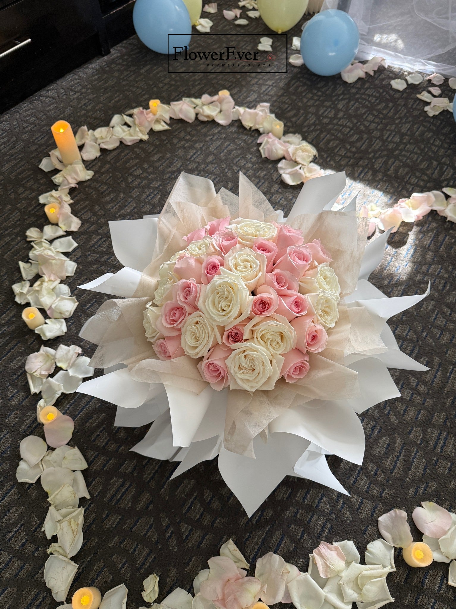Bouquet of pink and white flowers on a dark surface with decorative elements
