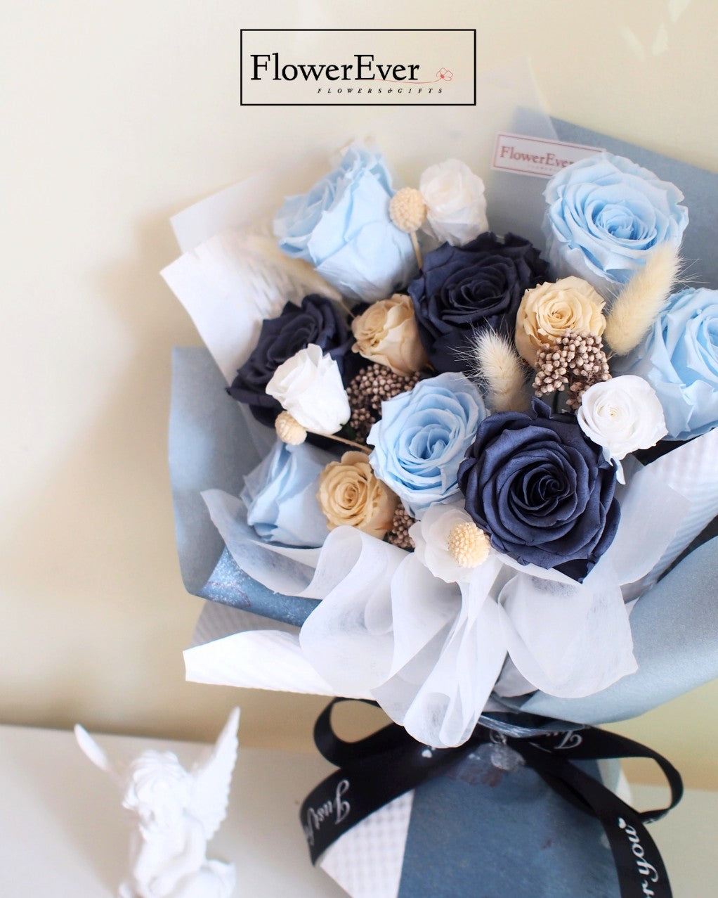 A colorful mixed bouquet featuring 12 vivid blue preserved roses accompanied by neutral white and nude floral stems.