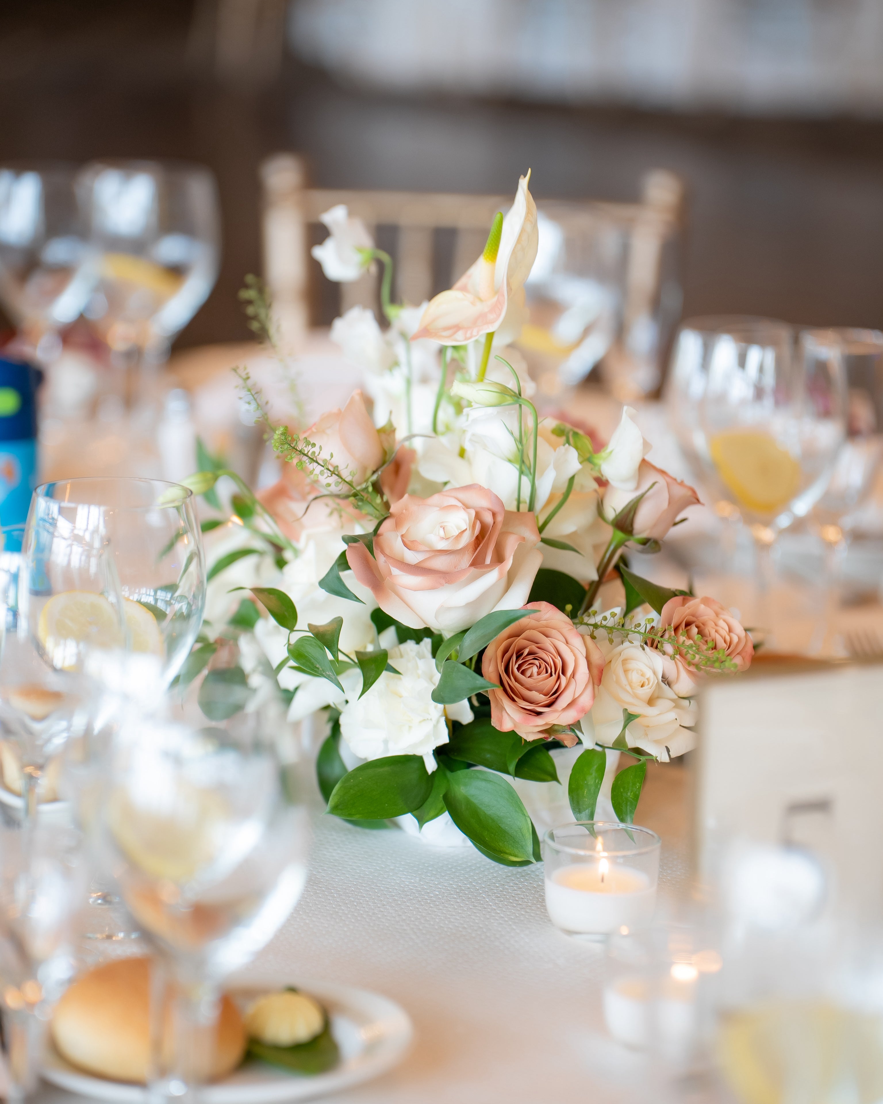 Floral arrangement on a table with candles and glasses