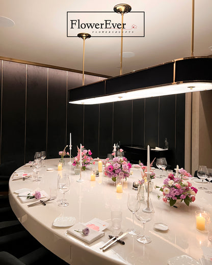 Elegant dining table setting with floral arrangements and candles, featuring the &