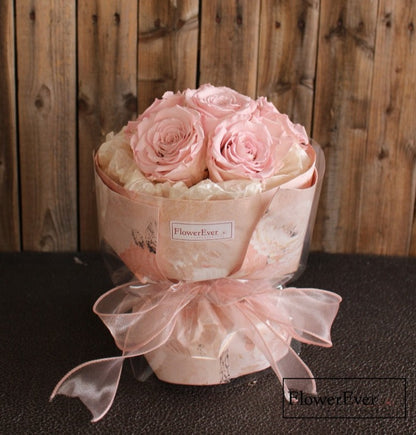 Six preserved flower stems including pink roses a statice arranged in a compact Russian-inspired floral bouquet