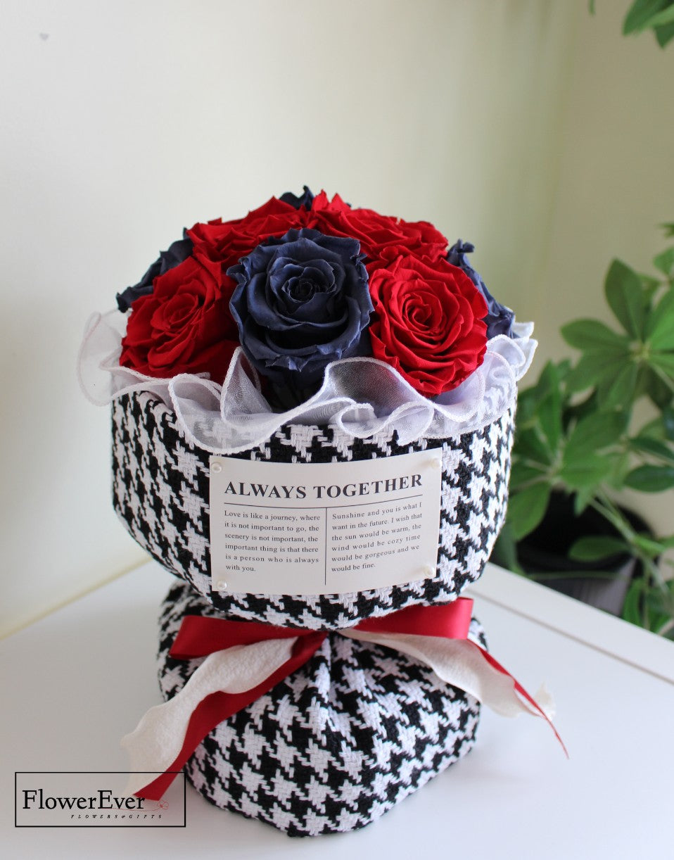 A Russian-inspired preserved floral bouquet containing 12 red and blue rose stems wrapped in a Chanel signature houndstooth patterned paper.