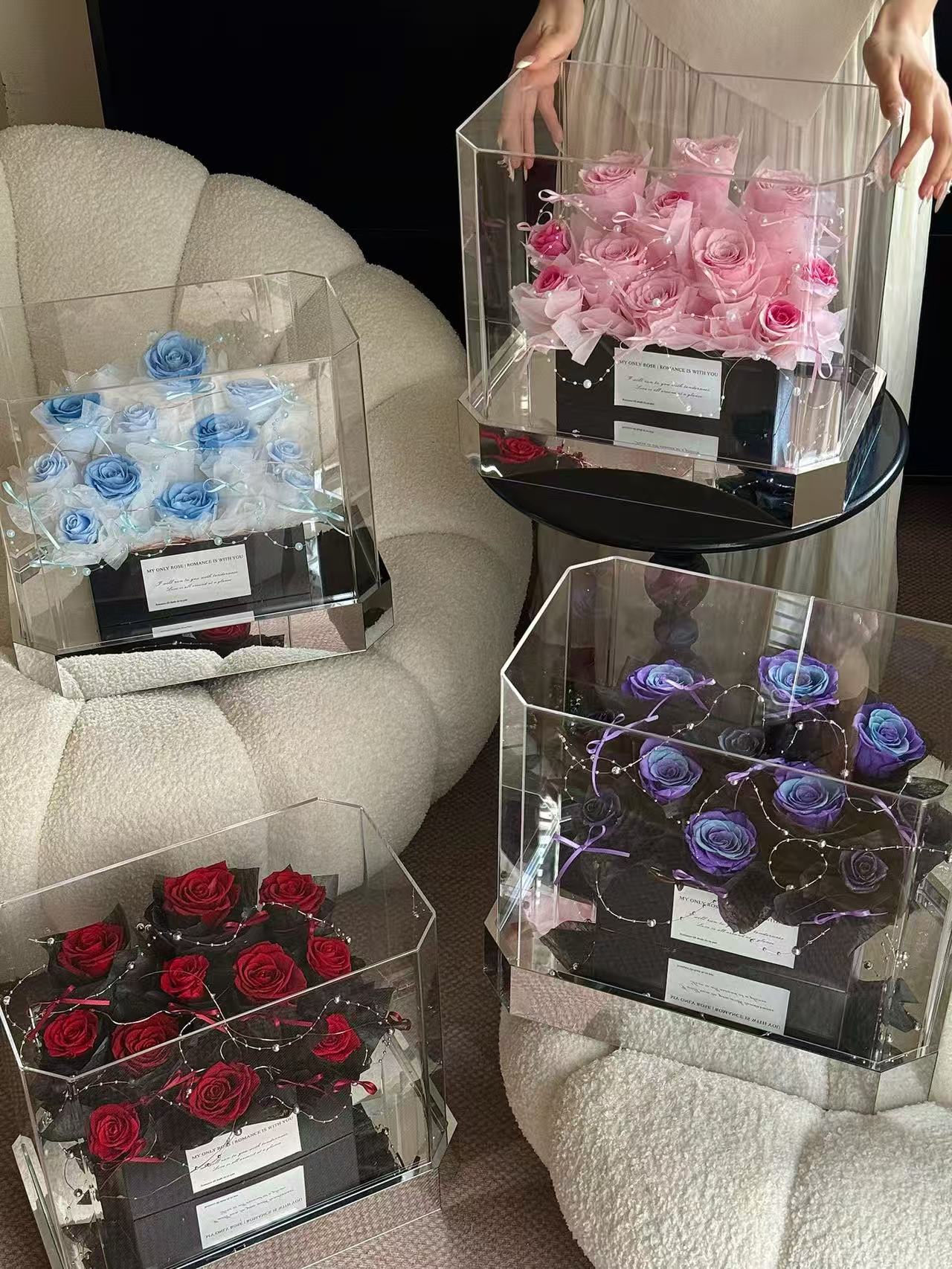 Glass display cases with pink, blue, and red roses on a couch.