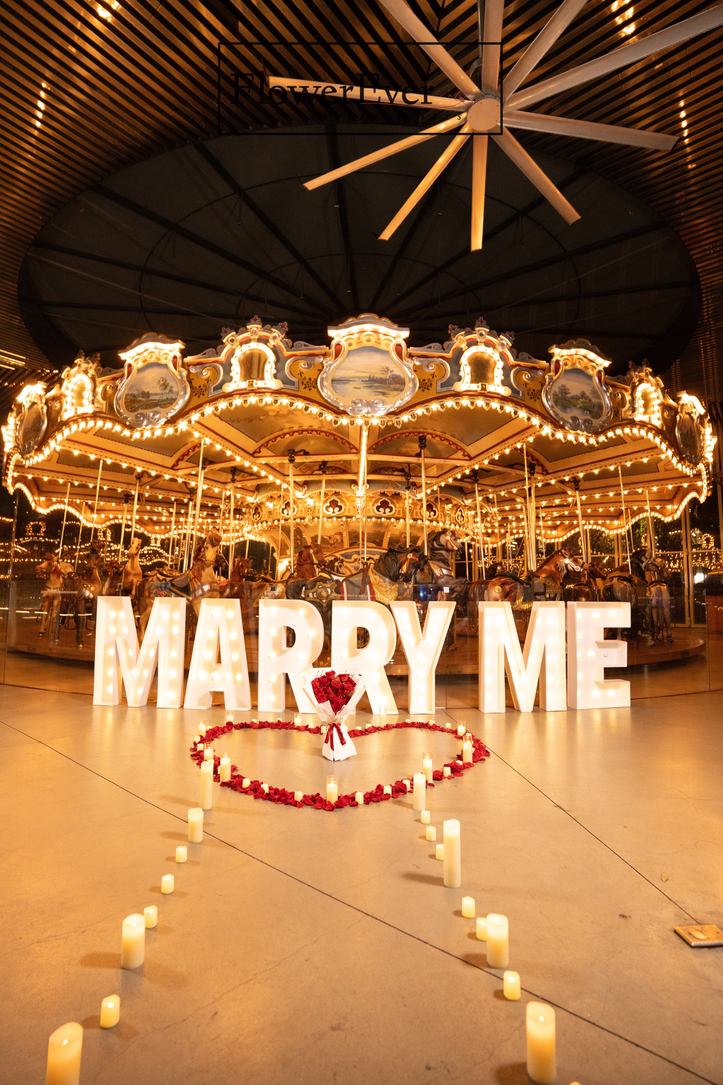 Whimsical NYC proposal ambiance: large letters, candles, and petals