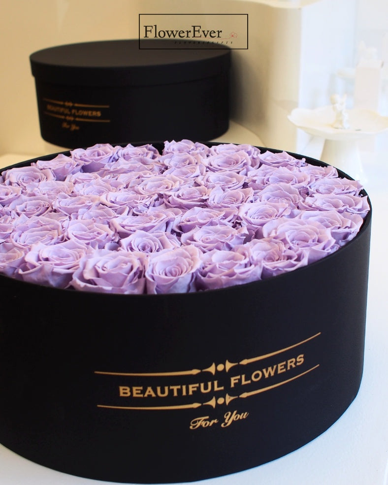 A beautiful floral gift presented in a black box containing 50 vivid purple preserved roses in various stages.