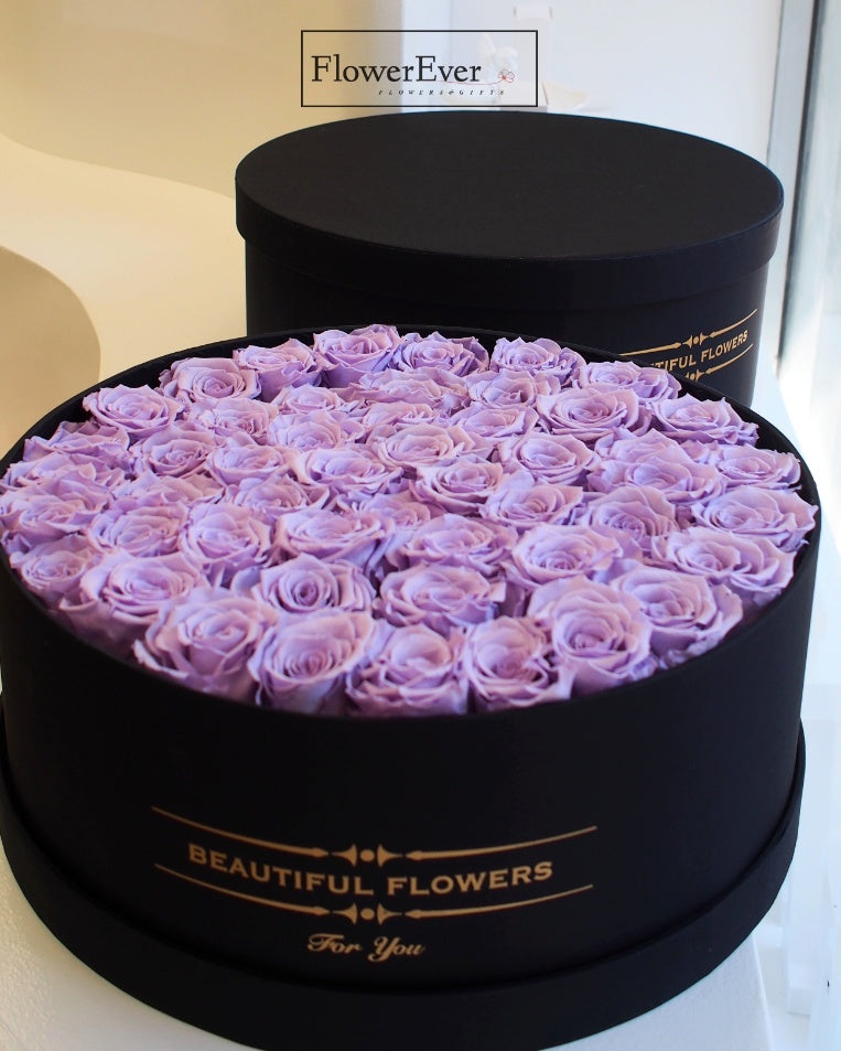 50 preserved purple roses in both tight buds and full blooms artistically arranged in a luxurious black gift box.