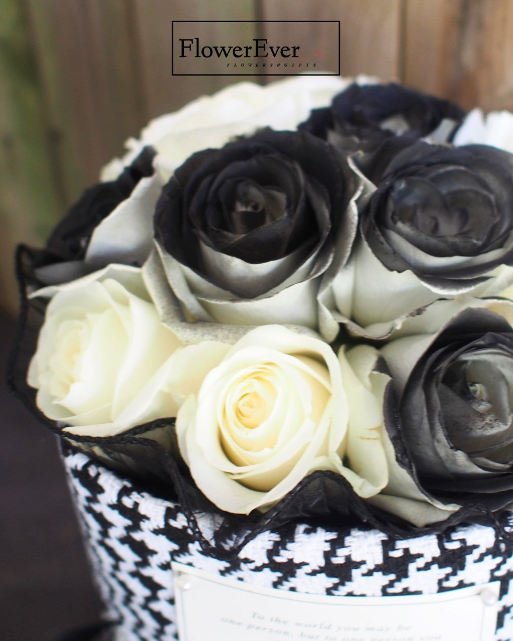 Dozen preserved white and black rose blooms arranged in a classic Russian bouquet tied with a Chanel signature black and white houndstooth paper wrap.