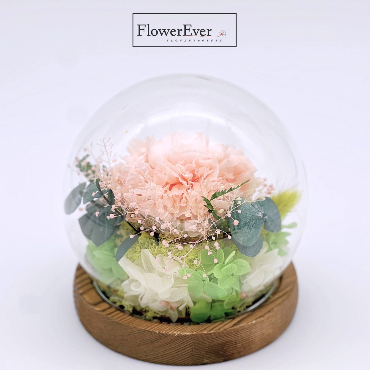 A clear glass dome showcasing preserved carnations in shades of white presented as a gift for mom