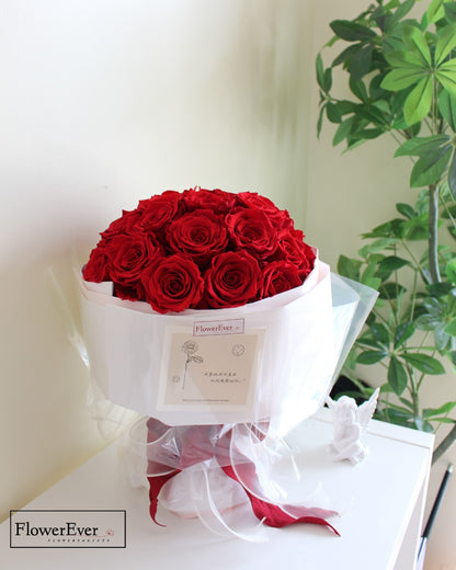 A Russian style round preserved rose bouquet containing 33 crimson rose stems presented in white wrapping.