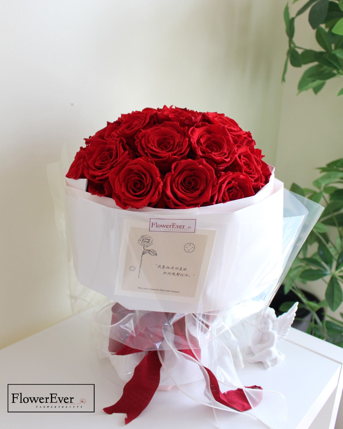 A round Russian style floral bouquet with 33 vivid red preserved rose stems wrapped in white paper.