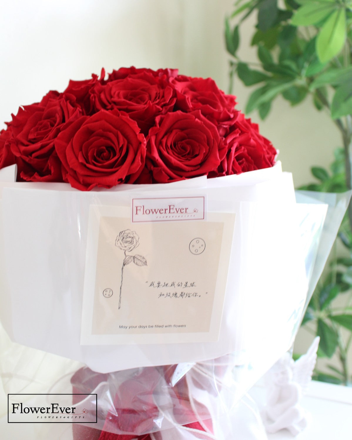 33 stems of crimson preserved roses arranged in a round Russian floral style bouquet in white gift wrap