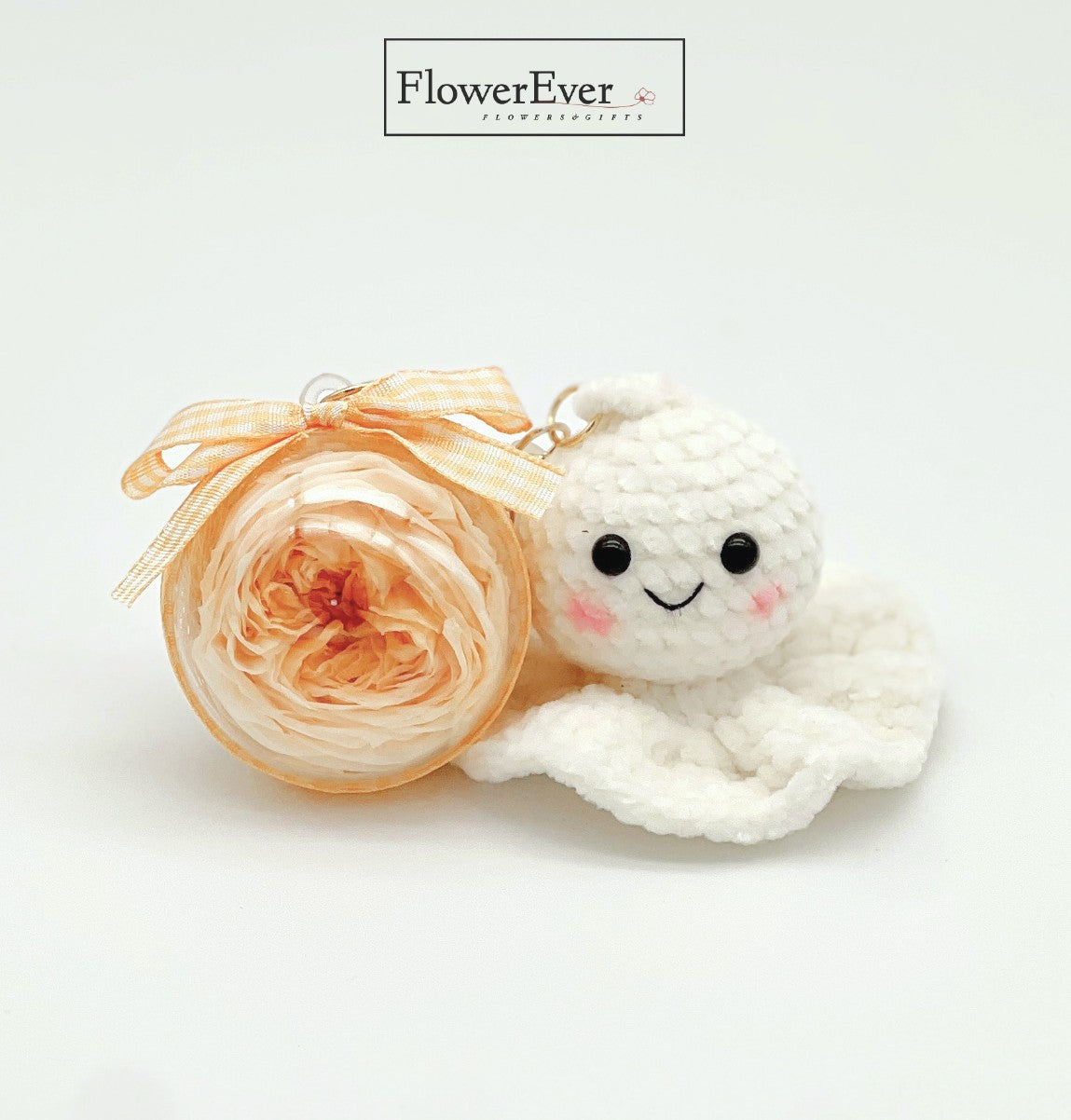 A handmade crochet teru teru bozu good weather charm decorated with a petite preserved sunflower.