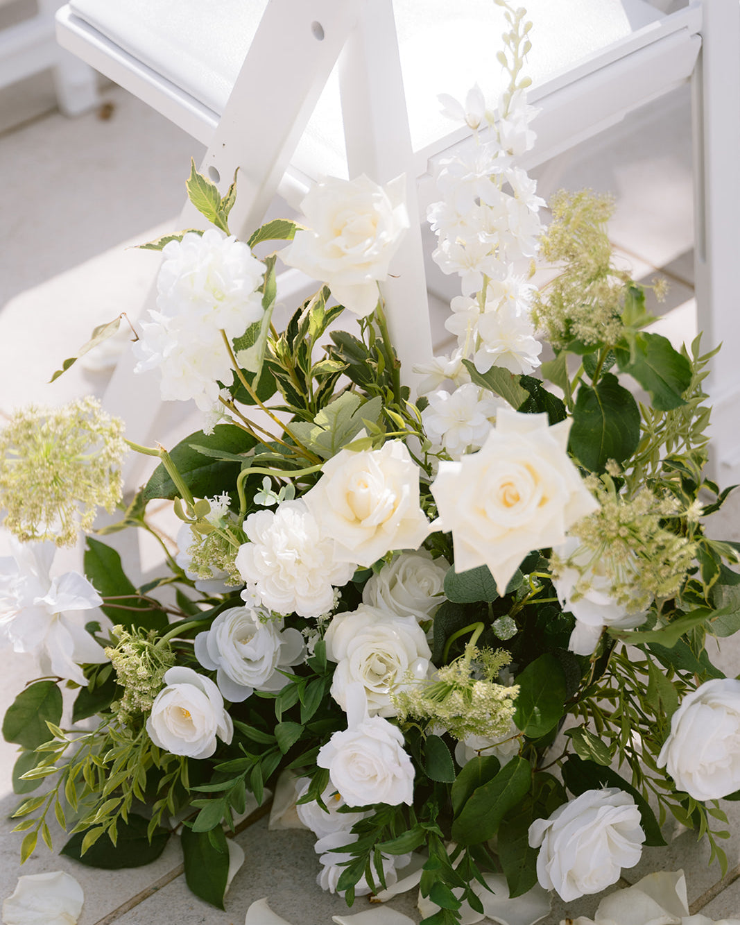 Bouquet of white flowers with greenery on a white wooden surface