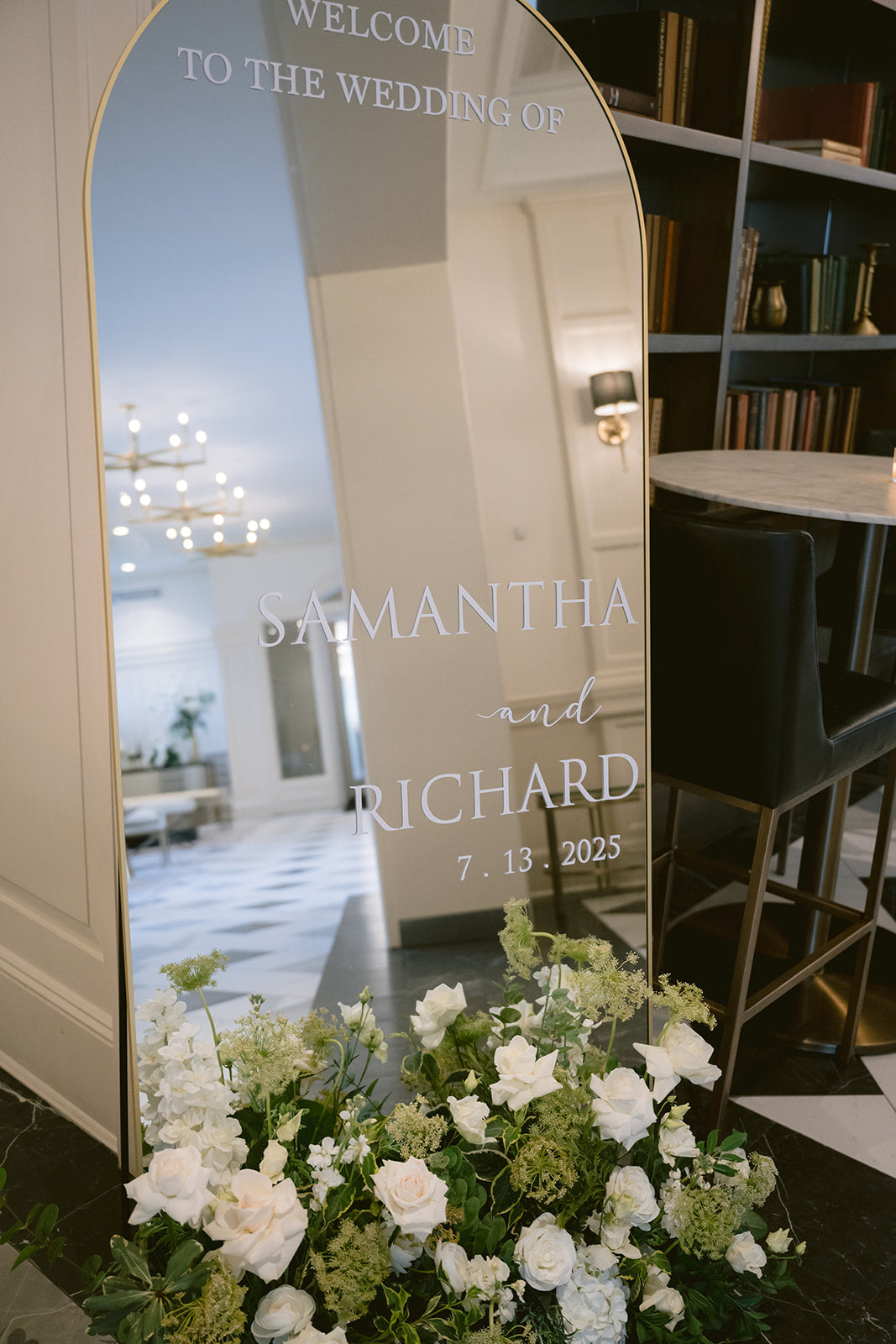 Decorative mirror with personalized text in a room with flowers and furniture.