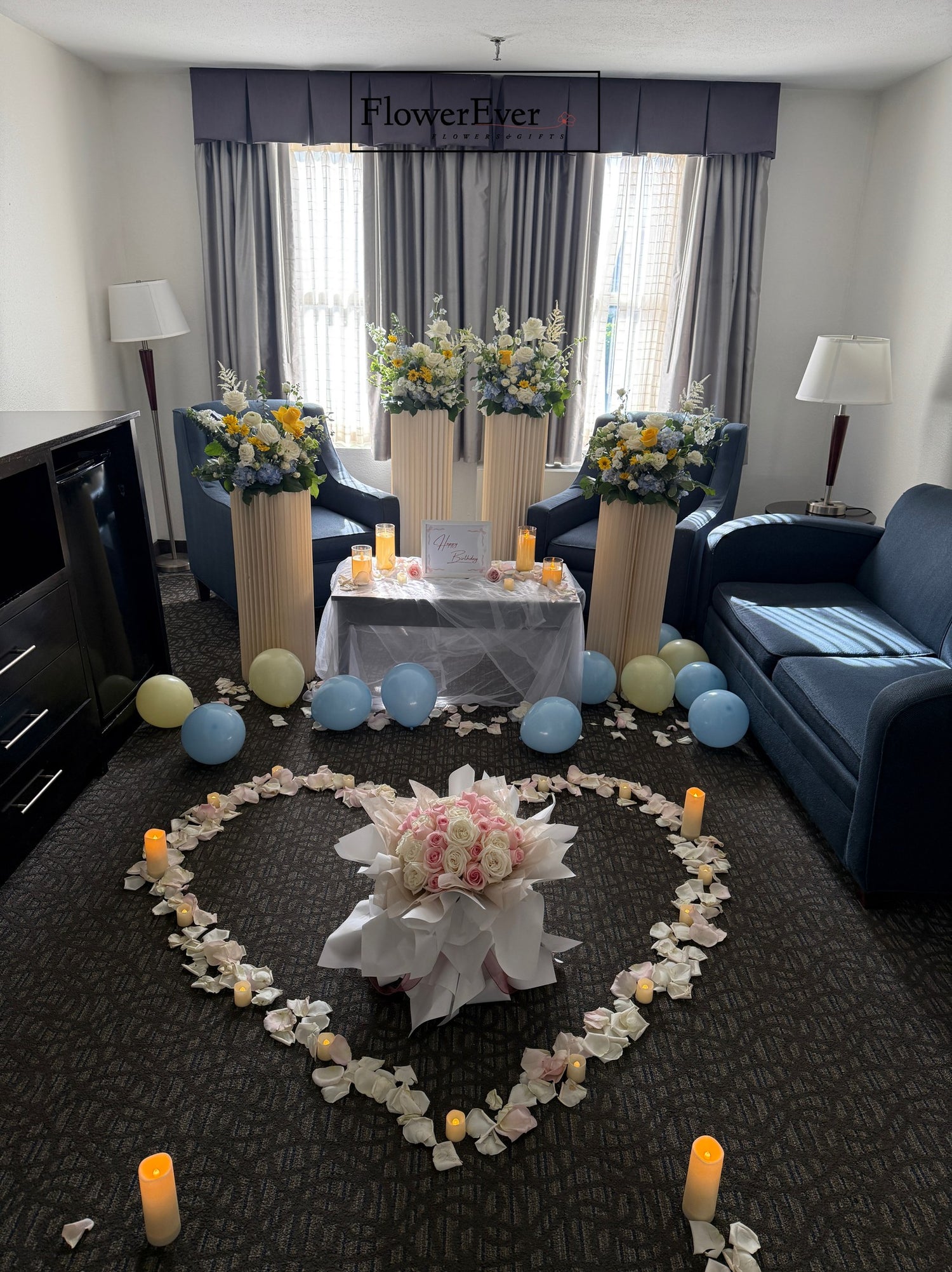 Decorative setup with flowers, candles, and balloons in a living room.