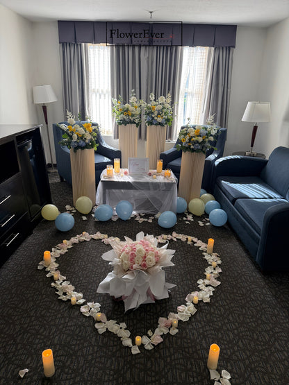 Decorative setup with flowers, candles, and balloons in a living room.