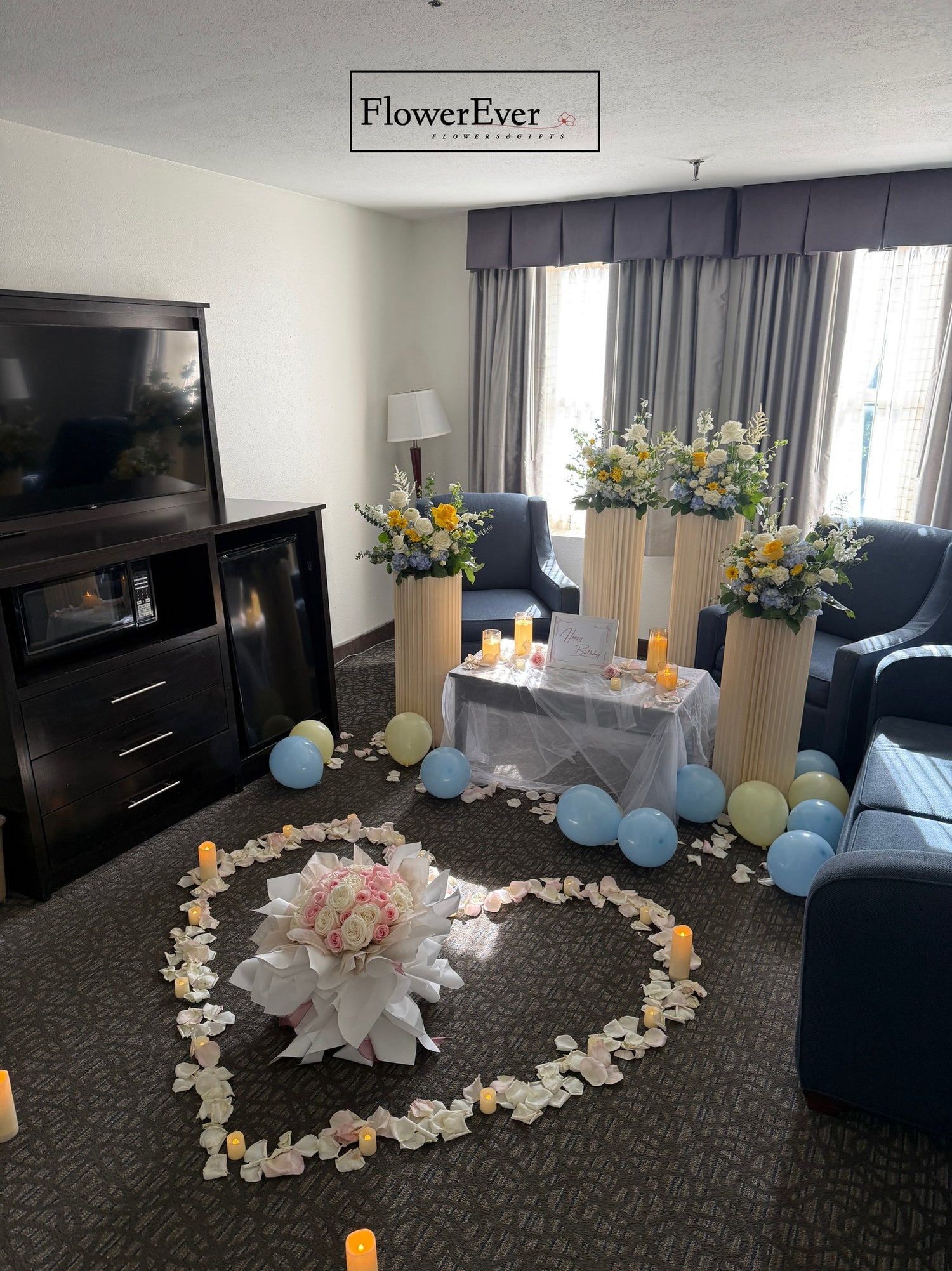Decorated living room with floral arrangements and balloons, featuring FlowerEver branding.