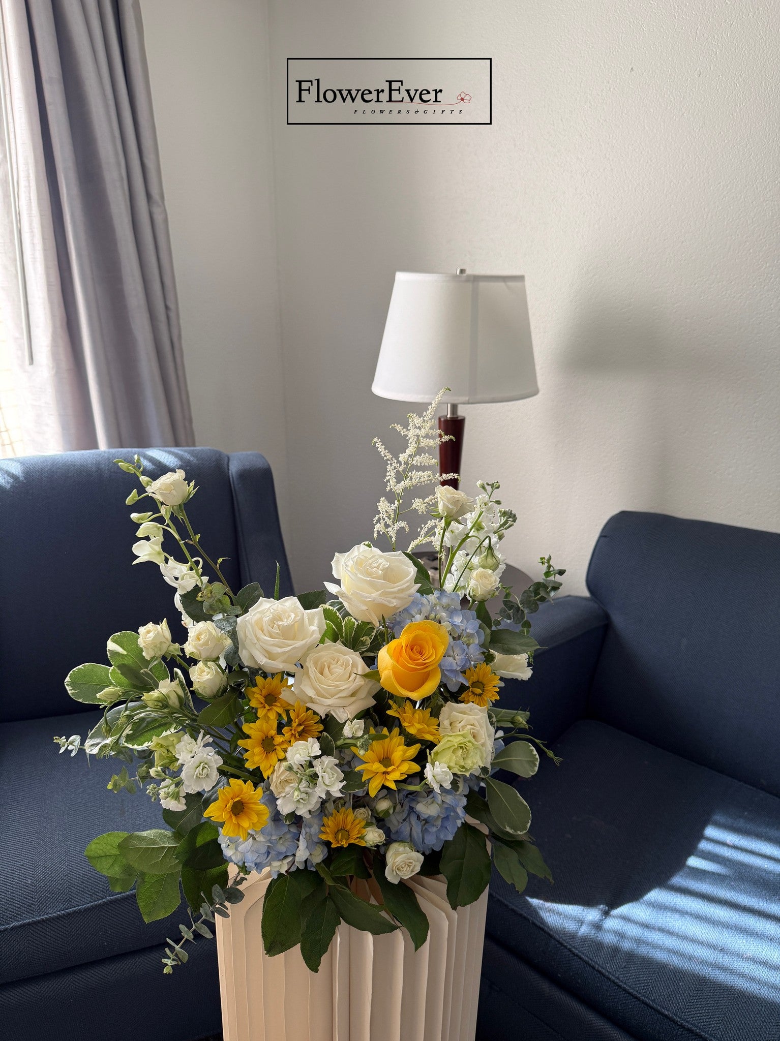 Floral arrangement in a vase on a coffee table with a &
