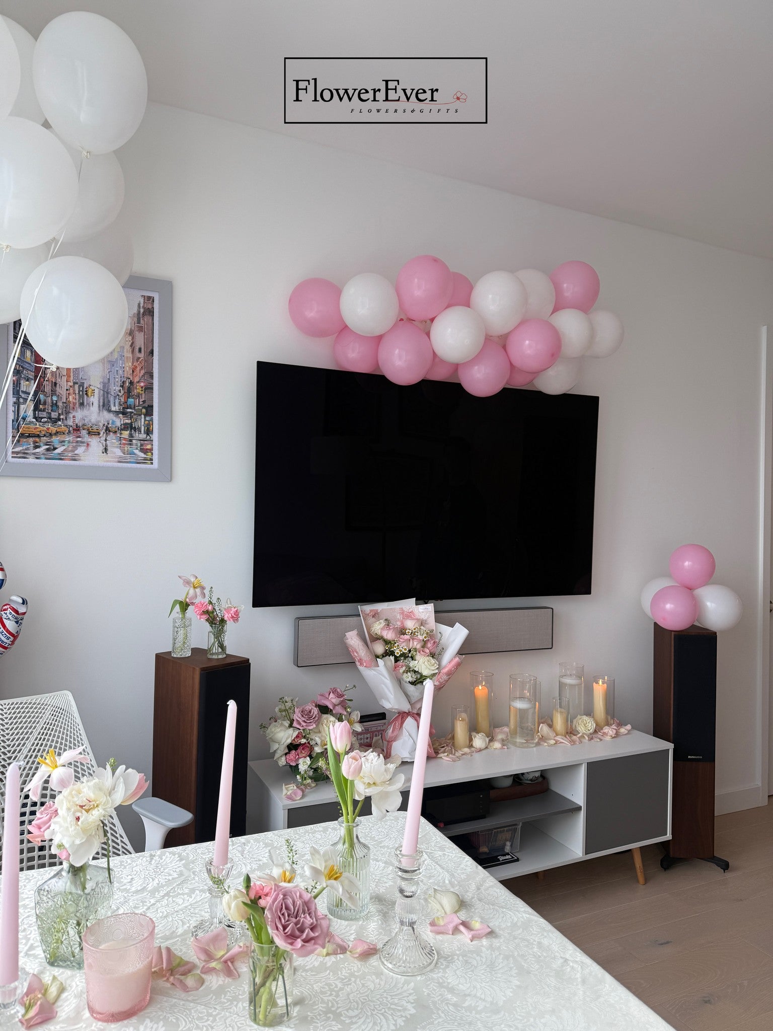 Decorated living room with balloons, flowers, and candles in a home setting.